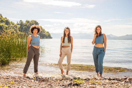 Three women standing lake front, modeling Linen pants and linen tank tops