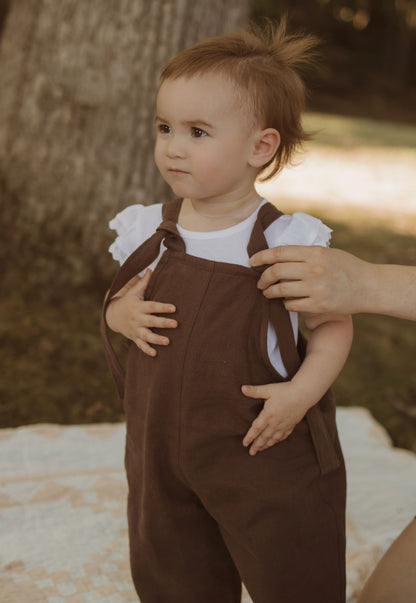 18 month old baby in Brown linen overalls 