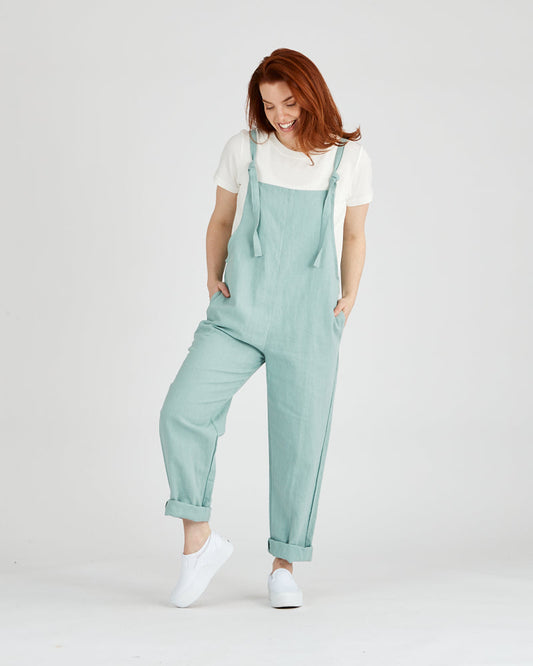 blue linen overalls on female model with hands in pockets